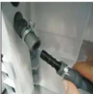 Close-up of a hand inserting a black plastic plug into a white container (no text or symbols visible)