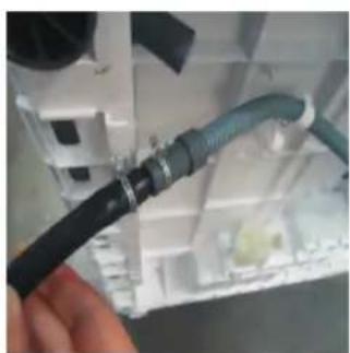Close-up of a hand holding a black cable with a blue cable inserted into a white electronic device (no visible text or symbols)