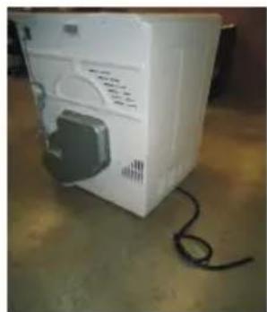 White industrial appliance with attached black component and coiled cable on floor (no visible text or symbols)