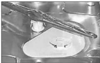 Close-up of a metallic mechanical component with a central circular feature and a diagonal tool inserted (no visible text or symbols)