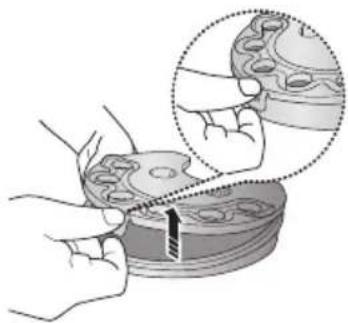 Illustration of hands using a tool to cut or mark a circular component, with an inset showing magnified detail (no text or symbols)