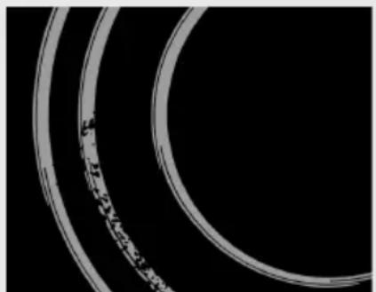 Close-up of two concentric circular rings with a textured inner ring, set against a black background (no text or symbols visible)