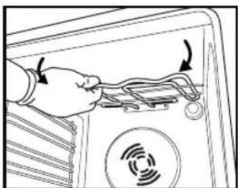 Diagram showing a hand connecting wires to an electronic device with a circular sensor icon (no text or symbols)