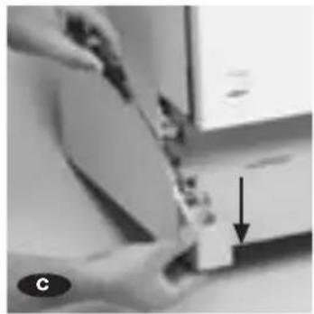 Close-up of hands holding a small object with an arrow pointing to it, no visible text or symbols.