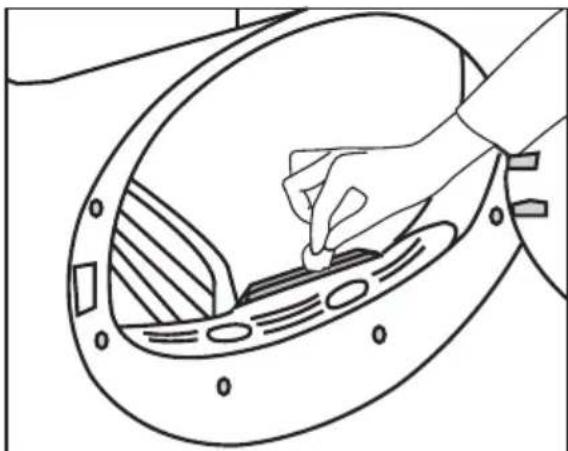 Line drawing of a hand inserting a small component into a circular device.