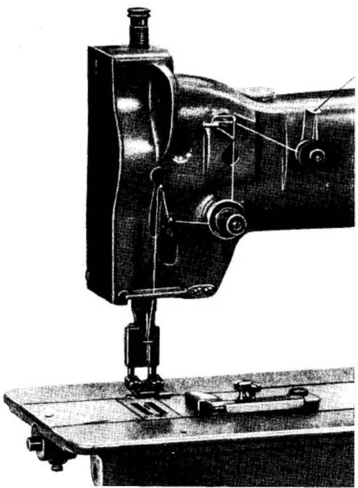 Photographie historique en noir et blanc d'une machine à coudre avec des pinces et une base de montage (sans texte ni symboles visibles).