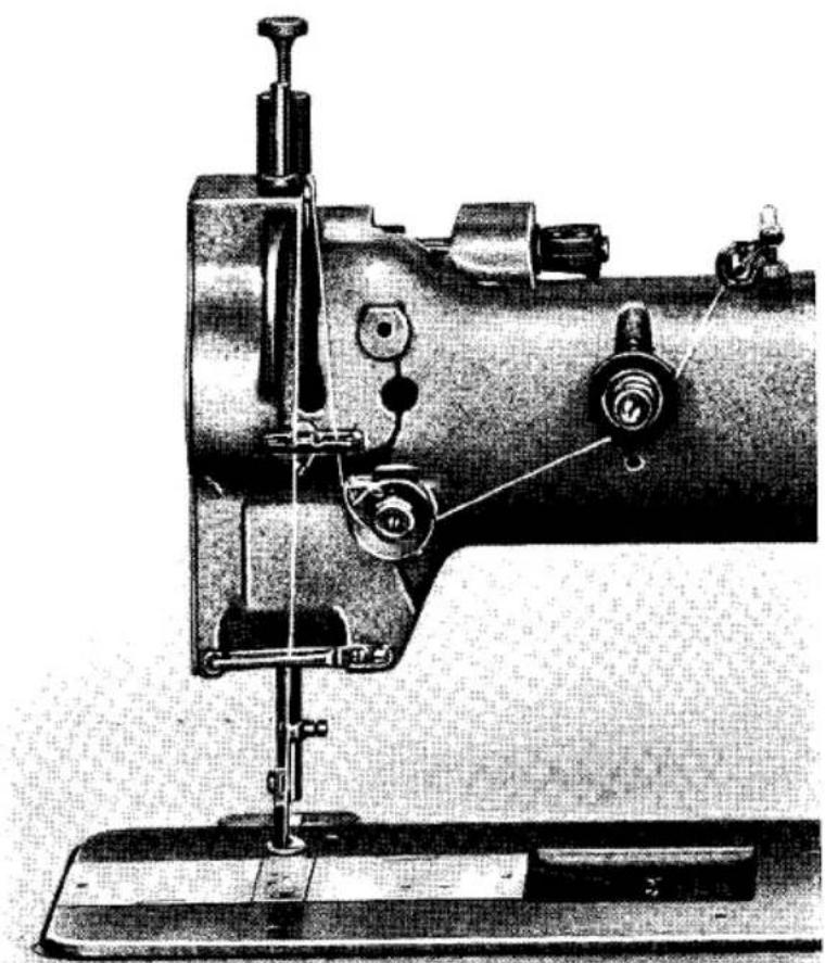 Illustration technique d'une machine à coudre avec des pinces et une base de montage (sans texte ni symboles visibles).