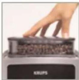 Hand pressing down on a black electronic device labeled 'KLUPS' (no other text or symbols visible)