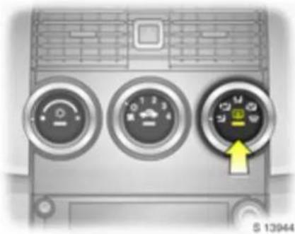 Front view of a car air conditioner unit with three dials and a yellow directional arrow (no text or symbols visible)