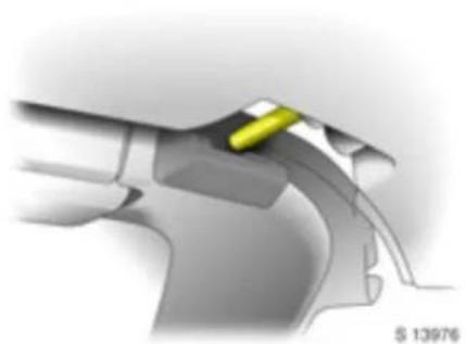 Close-up of a mechanical component with a yellow tool inserted, no visible text or symbols