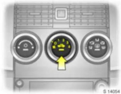 Front view of a car air conditioner unit with three dials and a yellow directional arrow (no text or symbols)