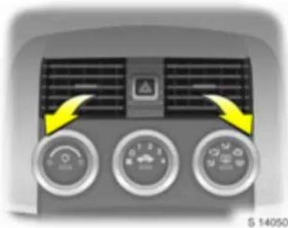 Close-up of a car air conditioner unit with three rotary gauges and a warning symbol (no text or labels visible)