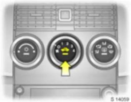 Front view of a car air conditioner unit with three dials and a yellow directional arrow (no text or symbols)