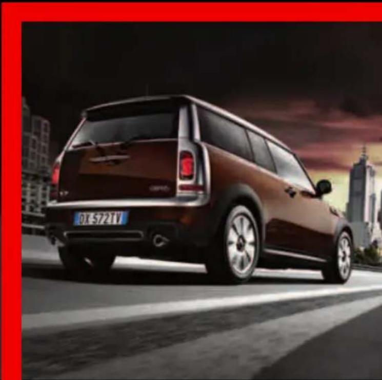 Rear view of a dark brown compact car on a city street with city skyline in background (no visible text or symbols)
