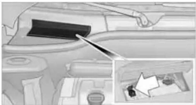 Interior view of a car dashboard with a tool pointing to the dashboard area, showing internal components and a small inset image of a vehicle (no visible text or symbols)
