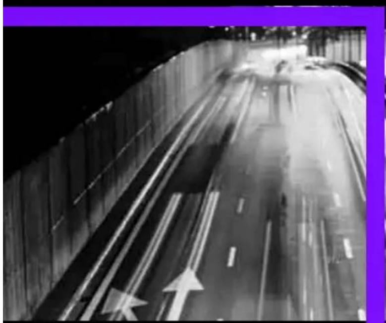 Black-and-white photo of a highway with multiple lanes and directional arrows, captured in motion (no visible text or symbols)