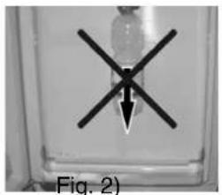 Close-up of a mechanical component with a black X-shaped mark and arrow, labeled Fig. 2 (no text or symbols on the object itself)