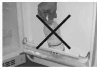 Interior view of a refrigerator with an open door and a black X mark on the lid (no visible text or symbols)
