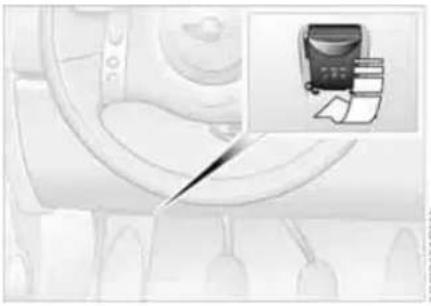 Interior view of a vehicle showing dashboard and seat area with an inset image of a printer (no text or symbols visible)