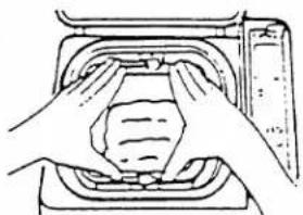 Line drawing of hands installing or adjusting a component inside a container (no text or symbols)