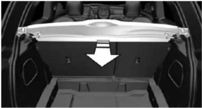 Interior view of a car showing a vehicle chassis with a white arrow pointing to the back panel (no text or symbols visible)