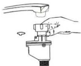 Illustration of a hand using a tool to lift a mechanical component (no text or symbols).
