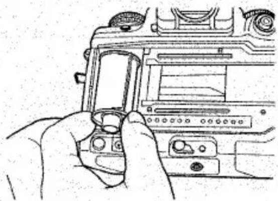 Dessin au trait d'une main tenant un module caméra, montrant l'écran et le panneau de commande de la caméra (sans texte ni symboles)