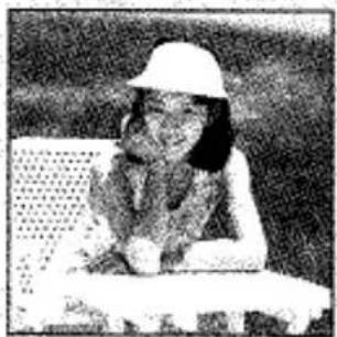 Photo en noir et blanc d'une personne portant un chapeau blanc et tenant une tablette (sans texte ni symboles visibles)