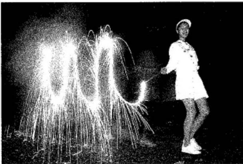 Photographie en noir et blanc d'une personne en uniforme tenant une fontaine à eau, avec de brillantes traînées de lumière et aucun texte ou symbole visible.