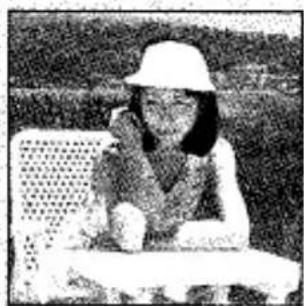 Photo en noir et blanc d'une personne assise à une table avec un téléphone, sans texte ni symboles visibles