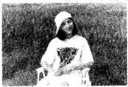 Photographie en noir et blanc d'une personne portant une chemise à capuche avec un logo (aucun texte ou symbole visible)
