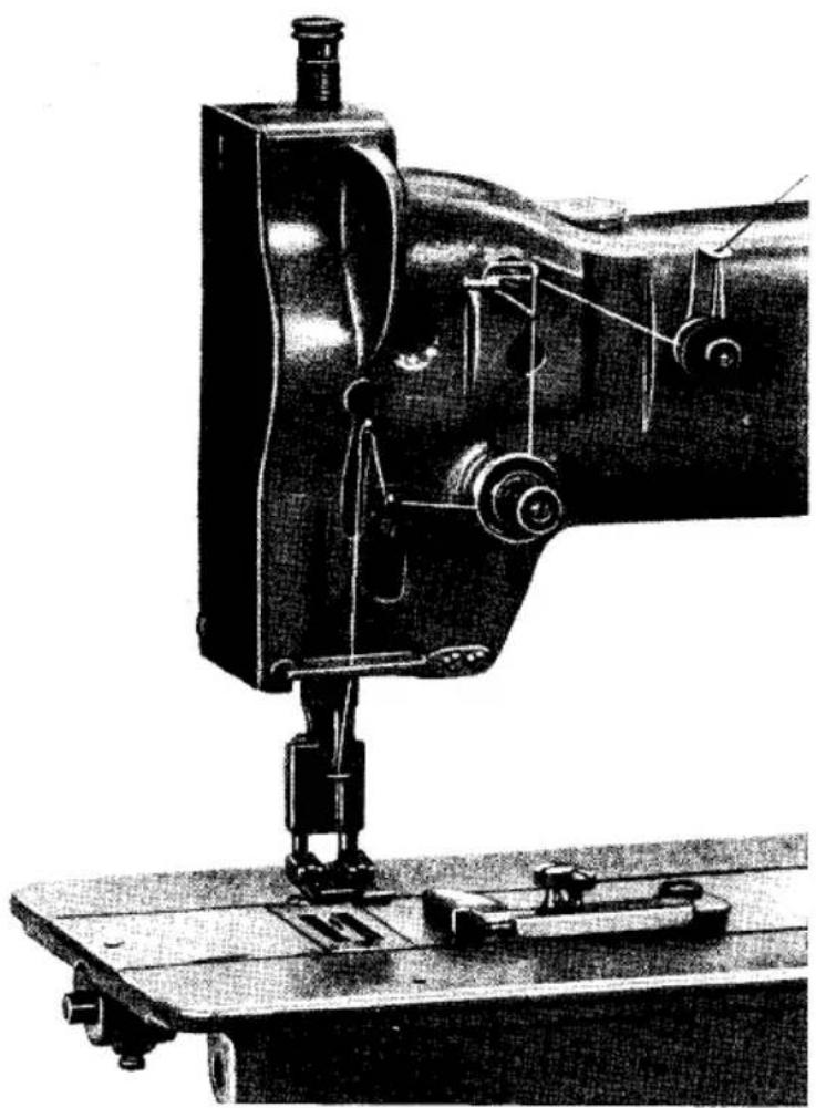 Photographie historique en noir et blanc d'une machine à coudre avec des composants mécaniques et une base de montage (sans texte ni symboles visibles).