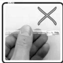 Image showing a finger holding a pen with a red X symbol and partial text 'E' visible at the top.