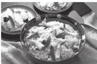 Black-and-white photo of a plated dish featuring sliced lotus root and garnish, with no visible text or symbols.