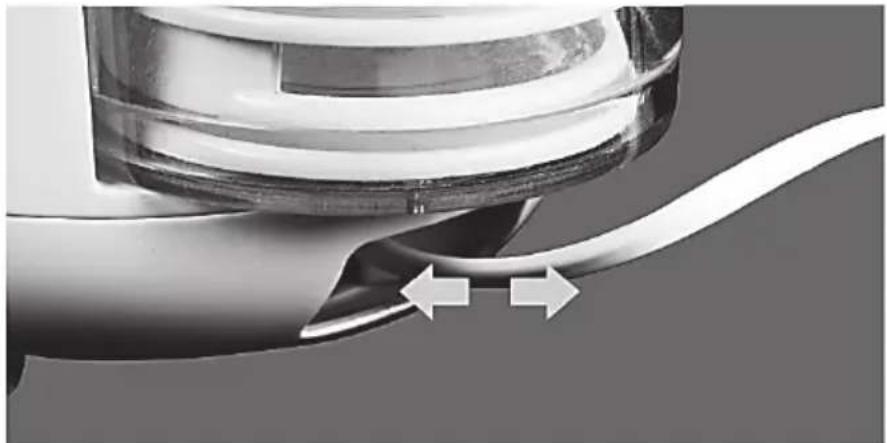 Close-up of a mechanical component with a curved wire and two directional arrows indicating motion (no text or symbols)