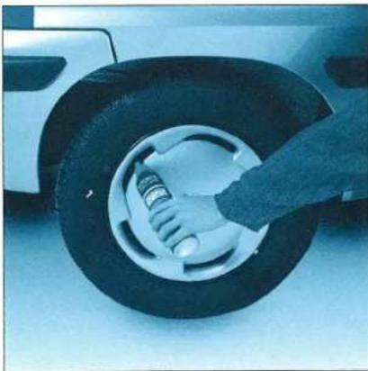 Close-up of hands adjusting a car tire with a spring (no visible text or symbols)