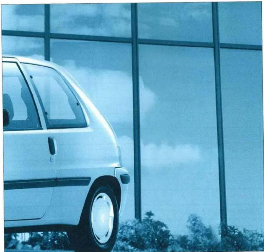 Side view of a white car parked in front of a modern glass building with sky reflection (no visible text or symbols)