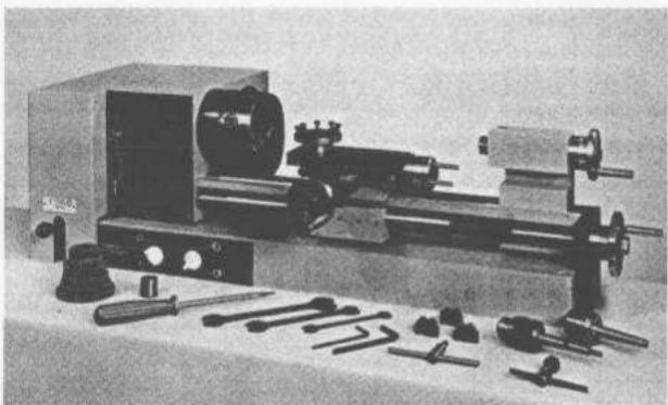 Black-and-white photo of a vintage mechanical optical setup with lenses, mirrors, and tools (no visible text or labels)