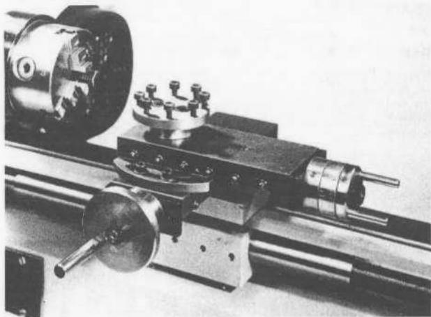 Close-up of a mechanical lathe machine with rotating components and a shaft (no visible text or symbols)