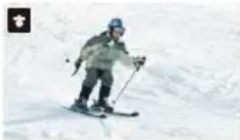 Skier in action on snowy slope, wearing helmet and gear (no visible text or symbols)