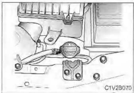 Technical diagram of a vehicle engine component with hoses and valve (no text or symbols visible)