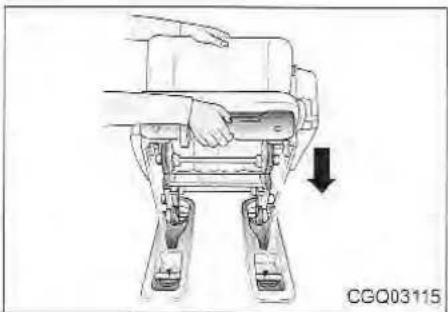 Line drawing of a robotic device with hands operating it, showing a downward arrow indicating motion (no text or symbols present)
