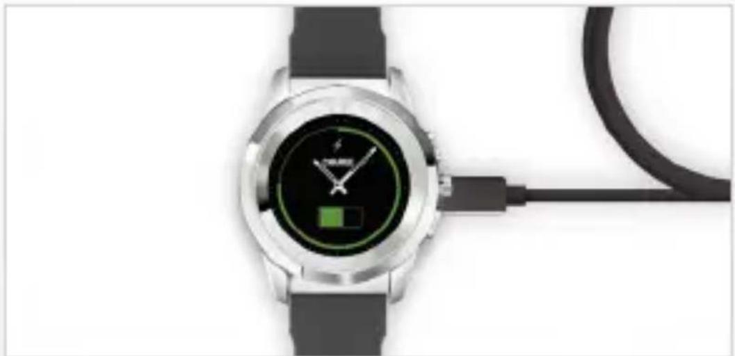 Close-up of a smartwatch with a black cable and green battery icon, no visible text or symbols on the watch face.