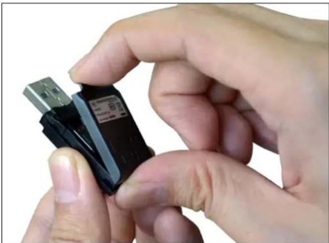 Close-up of hands holding a black USB flash drive (no visible text or symbols)