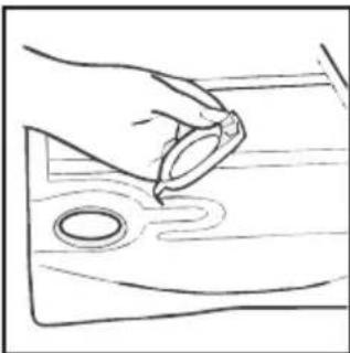 Simple line drawing of a hand holding a ring above a wooden surface with two circular holes (no text or symbols)