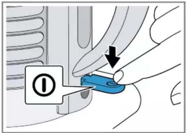Diagram showing a hand using a blue tool to press a button labeled with an 'I' symbol, indicating a process or action.