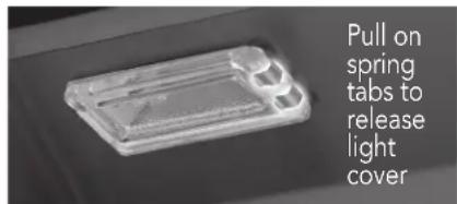 Pull on spring tabs to release light cover
