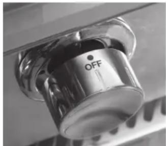 Close-up of a metallic kitchen sink with a circular knob labeled 'OFF' (no additional text or symbols visible)
