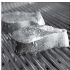 Close-up of two fish fillets on a bamboo steamer (no text or symbols visible)