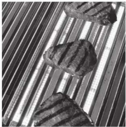 Close-up of three meatballs on striped cutting strips, no text or symbols visible.